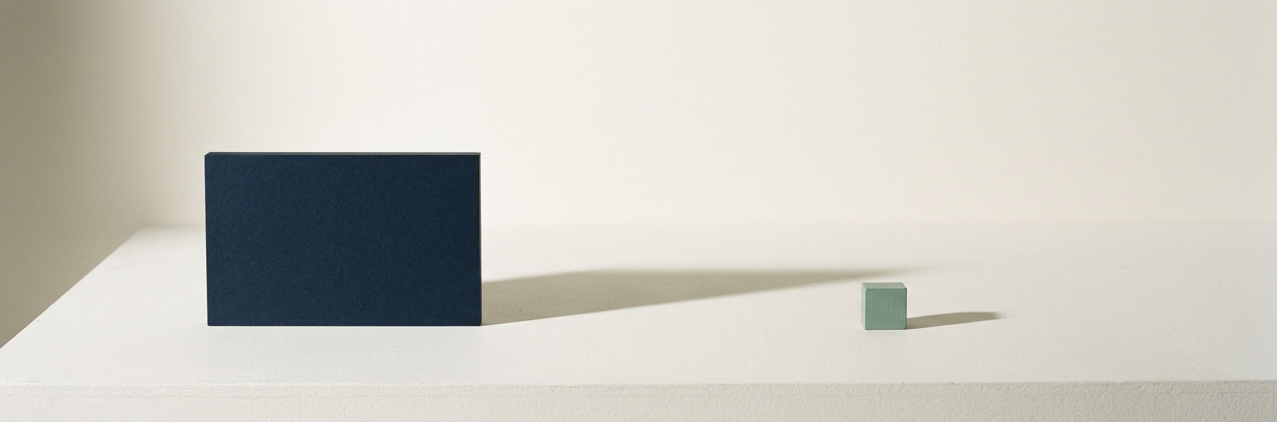 A single navy slab casting one long soft shadow across an empty surface, representing the trace a business leaves online.