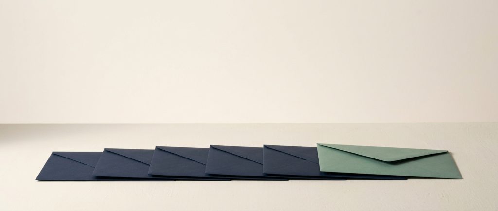 Six envelopes squared in a row, five navy and one sage, representing business email hosted on your own domain.