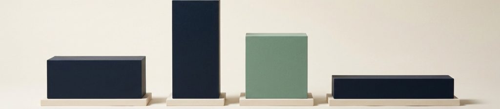 Four navy blocks of different proportions on identical bases with the third in sage.