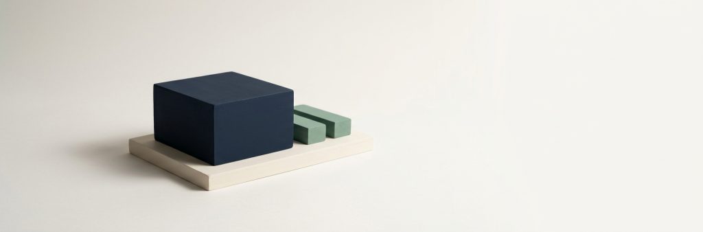 One navy block on a base beside two smaller sage blocks, representing a small operation kept in order.